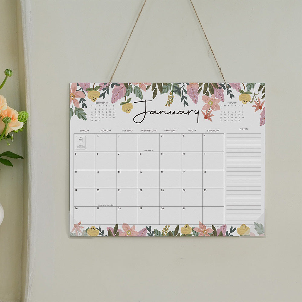 Floral calendar hanging on a wall with January page displayed