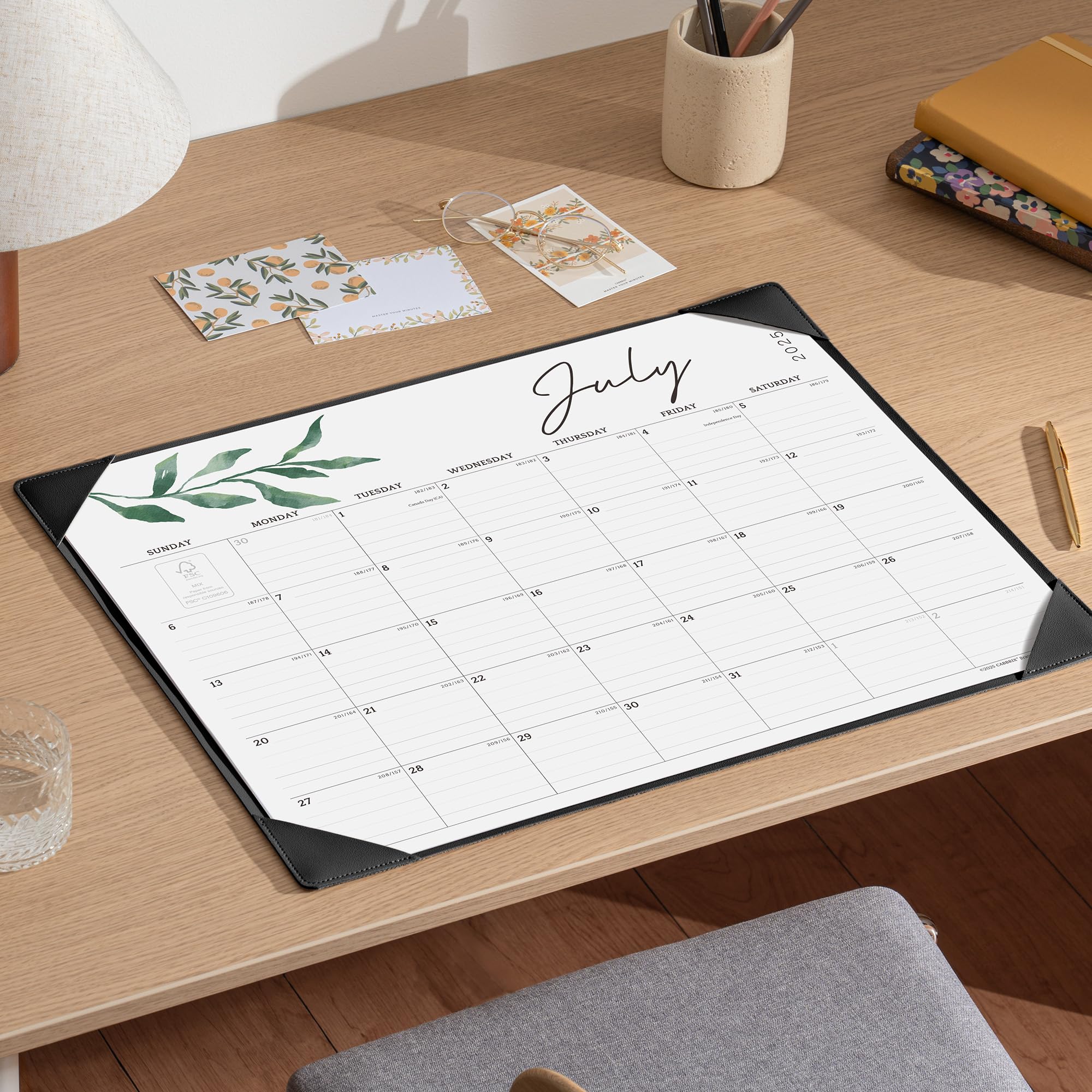 Calendar mat on a desk with stationery items